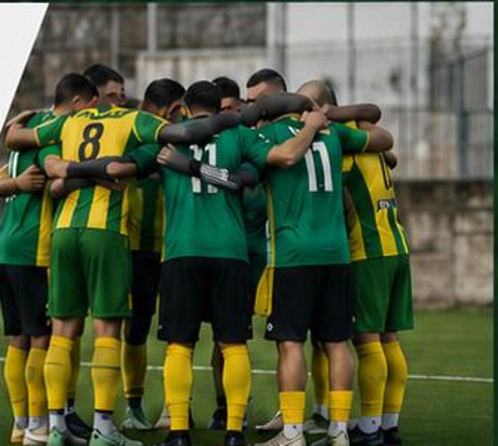 Achyronas-Onisilos players in a pre-match huddle